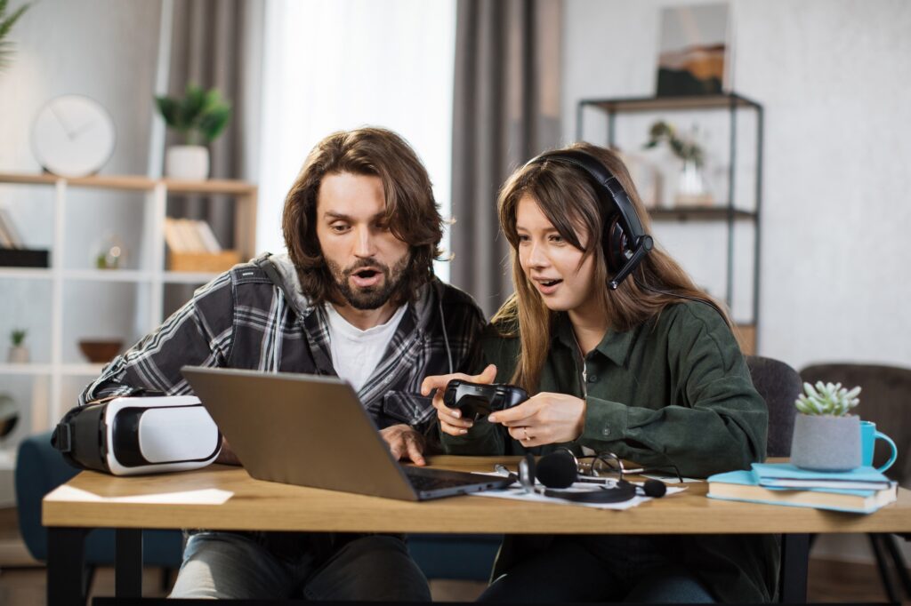 Excited young gamers enjoying a gaming session on their laptop, demonstrating the performance and value of the best budget gaming laptops 2025.