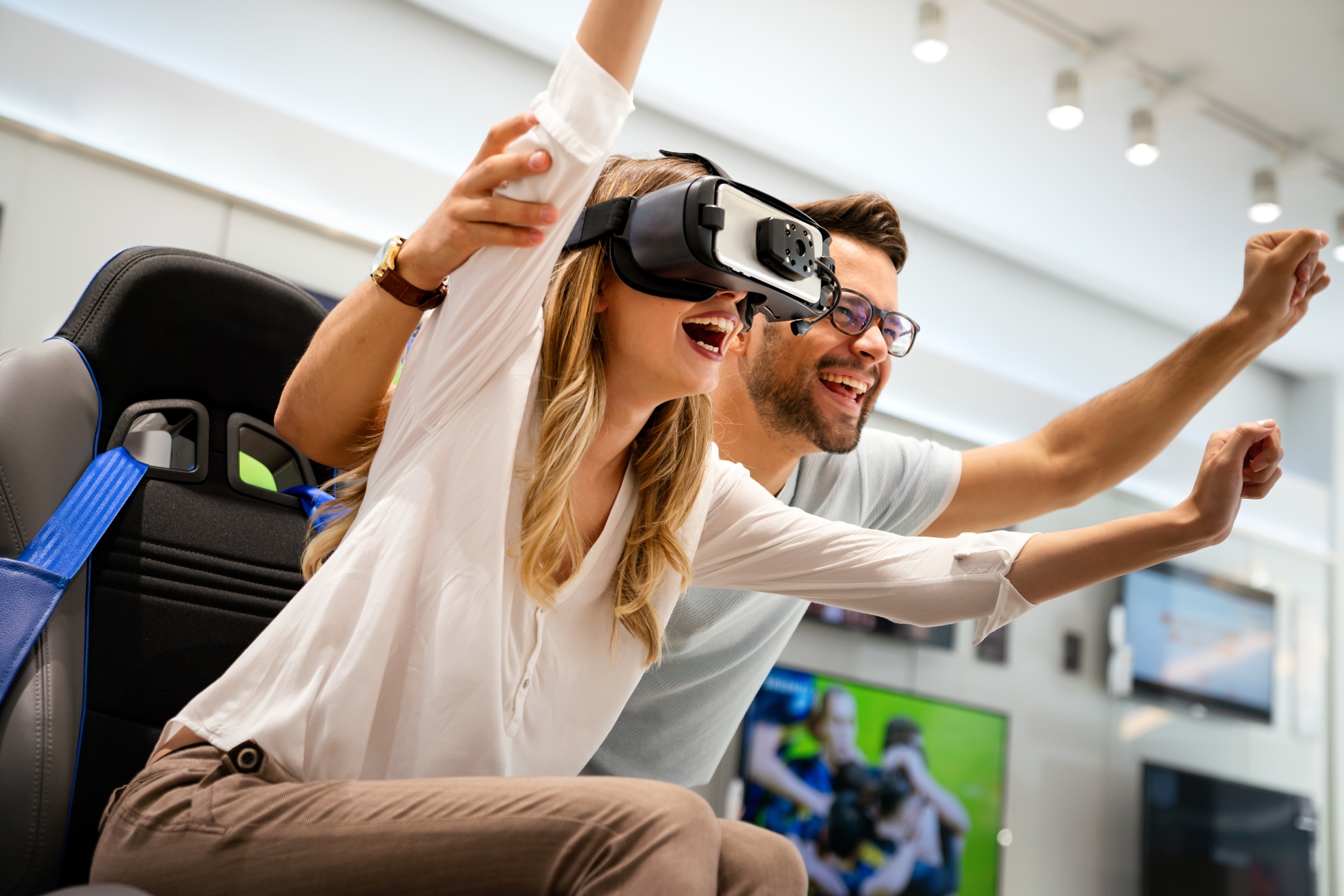 A joyful couple experiencing VR gaming in a high-tech retail environment — a dynamic visual capturing the innovation and excitement behind the UnitedTech brand story.

